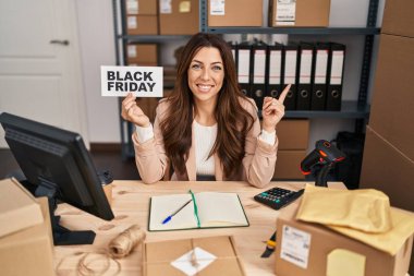 Genç esmer kadın elinde siyah cuma bayrağı küçük ticaret gülümsüyor mutlu bir el ve parmak kenarı işaret ederek 