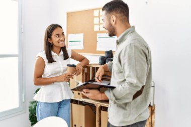 İki Latin iş adamı panoya yazı yazıp ofiste kahve içiyorlar..
