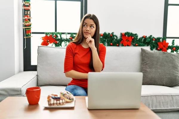 Jovem Morena Usando Laptop Sentado Sofá Natal Com Mão Queixo — Fotografia de Stock