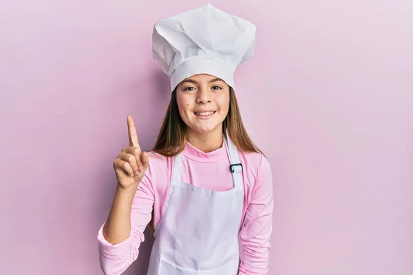Красива Брюнетка Маленька Дівчинка Професійному Кухонному Фартусі Капелюсі Посміхається Ідеєю — стокове фото