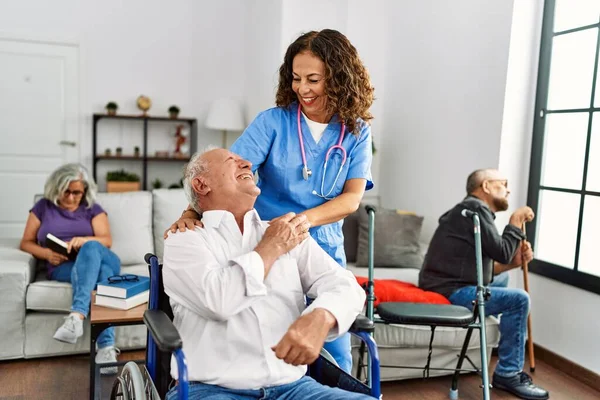 Medelålders Läkare Kvinna Stödja Pensionerad Man Sitter Rullstol Vårdhem — Stockfoto