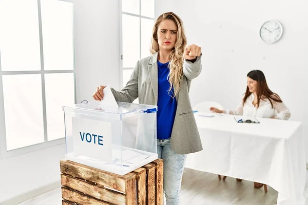 Νεαρή Ξανθιά Γυναίκα Που Ψηφίζει Βάζοντας Περιτύλιγμα Στην Κάλπη Δείχνοντας — Φωτογραφία Αρχείου