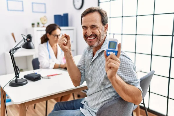 Homme Âge Moyen Clinique Médecin Tenant Dispositif Glycomètre Criant Fier — Photo