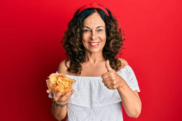 Mulher Hispânica Meia Idade Segurando Batata Frita Sorrindo Feliz Positivo — Fotografia de Stock