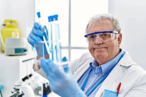 研究室で科学者の均一な保持試験管を身に着けている中年白髪の男 — ストック写真