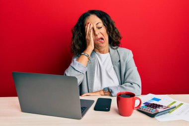 Ofiste çalışan orta yaşlı güzel bir kadın. Bir fincan kahve içiyor. Yarı yüz, göz ve ağız ile esnemekten yorgun düşüyor. Yüzüm acıyor.. 