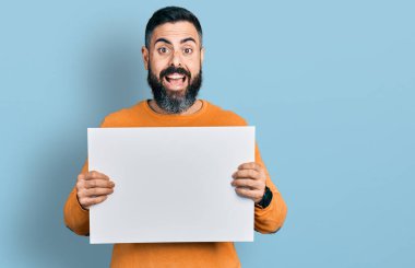 Sakallı, boş pankartı olan İspanyol bir adam çılgınca kutlama yapıyor ve gözleri açık heyecanla haykırıyor.. 