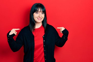 Gündelik kıyafetler giyen, kendine güvenen, gülümseyen, kendini gururlu ve mutlu gösteren genç İspanyol kadın.. 