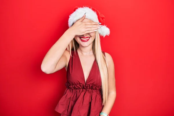 Молодая Блондинка Рождественской Шляпе Улыбается Смеется Закрывая Глаза Рукой Удивить — стоковое фото