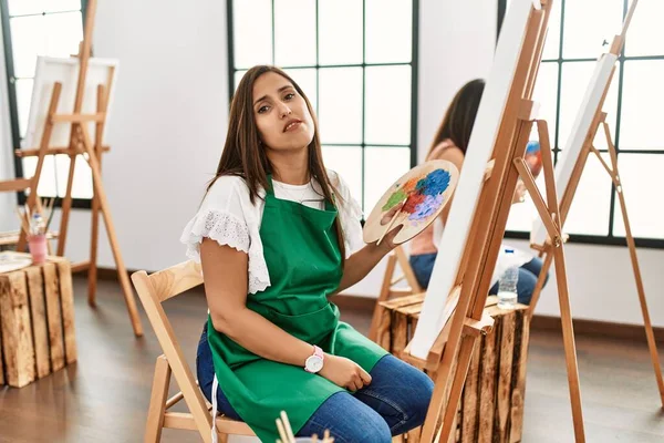 Młoda Latynoska Artystka Maluje Płótnie Pracowni Sztuki Wyglądając Senną Zmęczoną — Zdjęcie stockowe