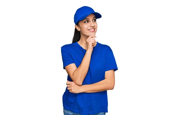 Young Hispanic Girl Wearing Delivery Courier Uniform Hand Chin Thinking — стоковое фото