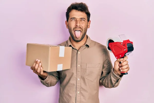Handsome Man Beard Holding Packing Tape Holding Cardboard Sticking Tongue — Stock Photo, Image
