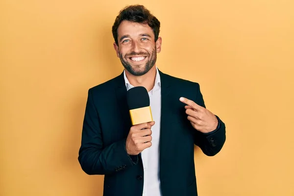 Hombre Guapo Con Barba Sosteniendo Micrófono Reportero Sonriendo Feliz Señalando —  Fotos de Stock