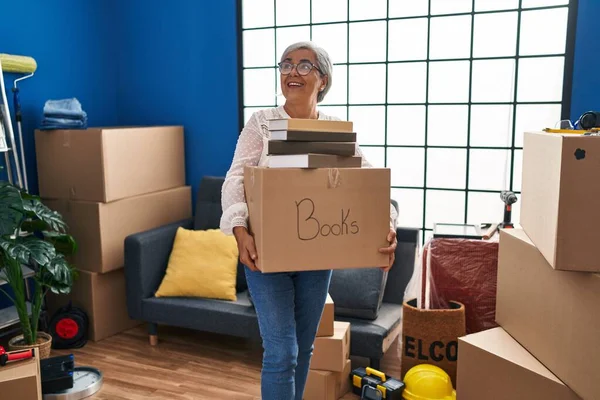 Frau Mittleren Alters Lächelt Zuversichtlich Und Hält Bücherpaket Neuen Zuhause — Stockfoto