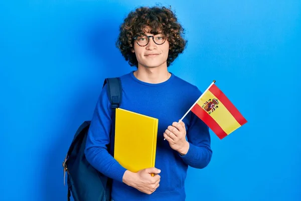 Handsome Young Man Exchange Student Holding Spanish Flag Smiling Happy — стоковое фото