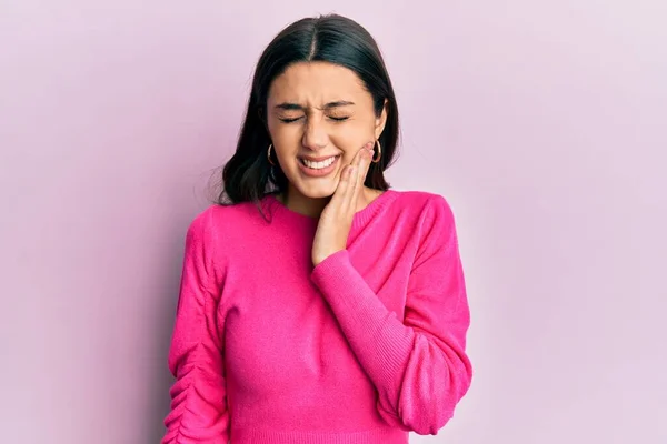 歯の痛みや歯の病気のために痛みを伴う表現で手に触れるカジュアルな服を身に着けている若いヒスパニック女性 歯科医 — ストック写真