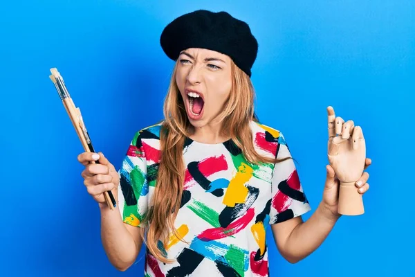 Young Caucasian Woman Artist Holding Small Wooden Manikin Paintbrushes Angry — Photo
