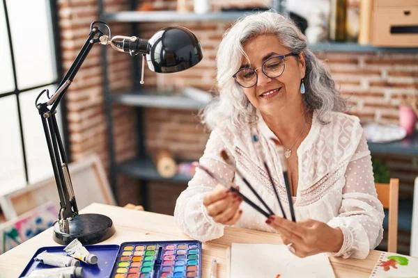Resim Stüdyosunda Fırça Tutan Orta Yaşlı Kadın Sanatçı Gülümsüyor — Stok fotoğraf