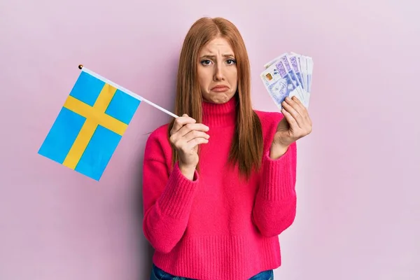 Young Irish Woman Holding Sweden Flag Krone Banknotes Depressed Worry — стоковое фото