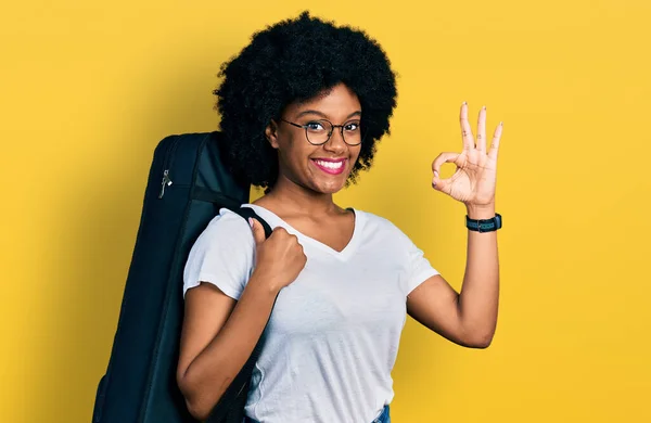Young African American Woman Wearing Guitar Case Doing Sign Fingers — ストック写真