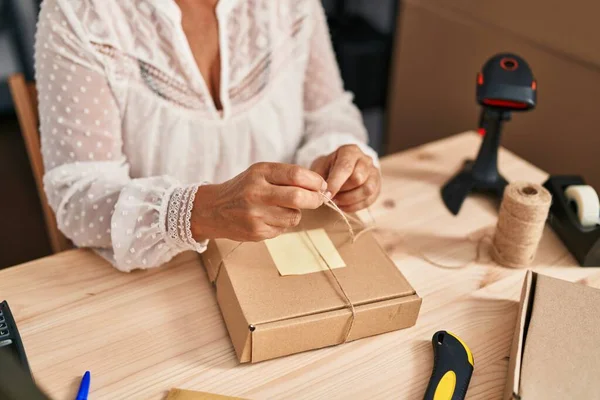 Orta yaşlı kadın ecommerce iş işçisi ofiste paket siparişi hazırla