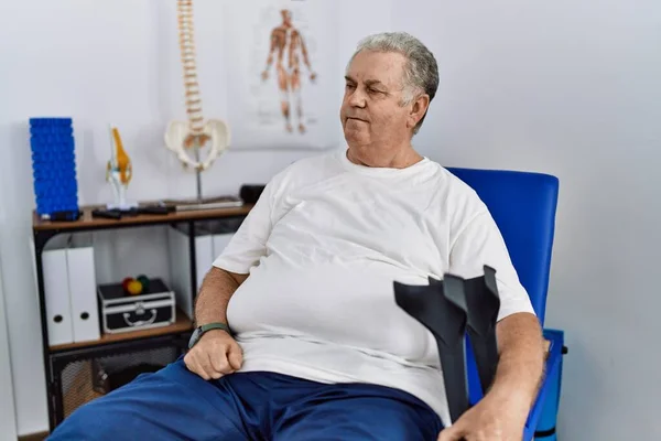 Homem Caucasiano Sênior Clínica Fisioterapia Segurando Muletas Olhando Para Lado — Fotografia de Stock
