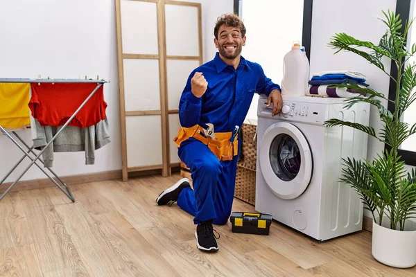 Çamaşır makinesinde çalışan Latin asıllı genç adam gururla bağırıyor, zaferi ve başarıyı kutluyor. 