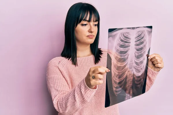 Mujer Hispana Joven Sosteniendo Radiografía Tórax Relajada Con Expresión Seria —  Fotos de Stock