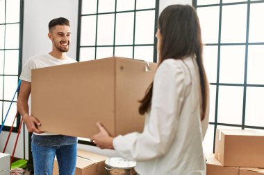 Genç İspanyol çift mutlu bir şekilde gülümsüyor. Karton kutular yeni evlerinde taşınıyor..