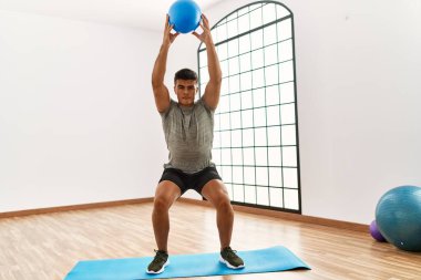 Genç İspanyol adam spor merkezinde topla antrenman yapıyor.