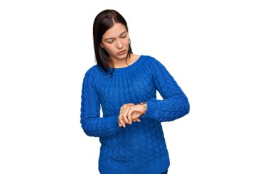 Gündelik kıyafetler giyen genç İspanyol kadın kol saatini kontrol ediyor, rahat ve kendinden emin. 