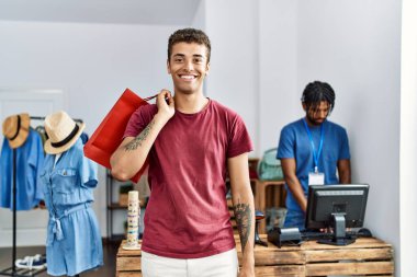 İki adam mağazada alışveriş torbaları tutuyor.