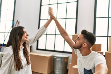 Genç İspanyol çift yeni evlerinde kollarını kaldırarak ev sembolü yapıyor..