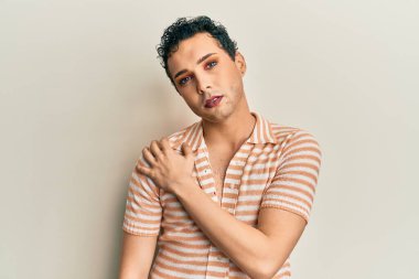 Makyaj yapan yakışıklı bir adam gündelik gömlek giyer ağzı elle kapatır, şok olur ve hata yapmaktan korkar. şaşırmış ifade 