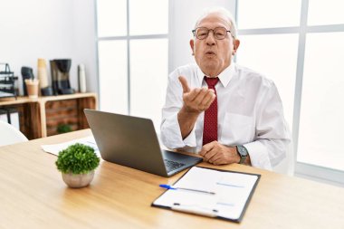 Ofiste çalışan son sınıf öğrencisi bilgisayarla kameraya bakıp havada öpüşürken çok güzel ve seksi görünüyor. aşk ifadesi. 