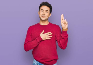 Genç, yakışıklı, sıradan kıyafetler giyen, gülümseyen, elleri göğsünde ve parmakları havada küfür eden, sadakat yemini eden bir adam. 