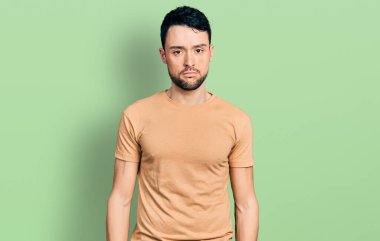 Sakallı, sıradan tişörtlü, uykulu, yorgun, bitkin, akşamdan kalma, tembel gözlü İspanyol bir adam.. 