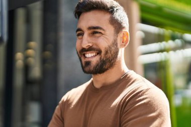 Parkta kendinden emin gülümseyen İspanyol genç adam.