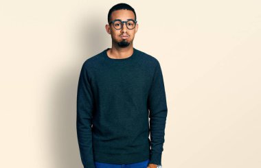 Sıradan kıyafetler giyen ve gözlüklü, komik yüzlü, yanak şişiren genç Afro-Amerikan bir adam. Havayla şişmiş ağız, çılgın bir ifade.. 