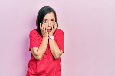 Orta yaşlı İspanyol kadın gündelik kıyafetler giyiyor. Yorgun eller, yüzünü kapatıyor. Depresyon ve üzüntü yaşıyor. 