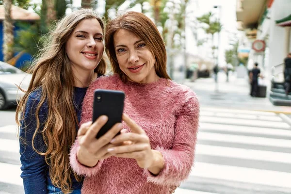 Mãe Filha Abraçando Uns Aos Outros Usando Smartphone Rua — Fotografia de Stock