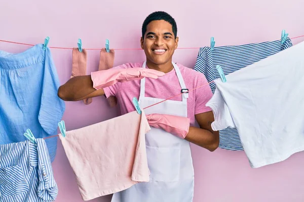 Young Handsome Hispanic Man Wearing Cleaner Apron Holding Clothes Clothesline — Fotografia de Stock