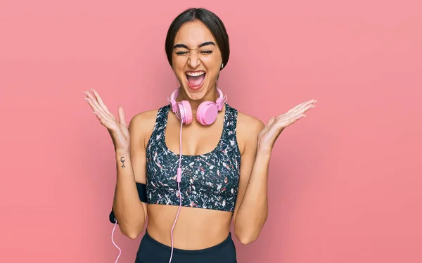 Beautiful Brunette Woman Wearing Gym Clothes Using Headphones Celebrating Mad — Stockfoto