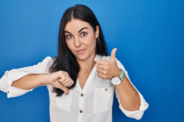Young Hispanic Woman Standing Blue Background Doing Thumbs Disagreement Agreement — Fotografia de Stock