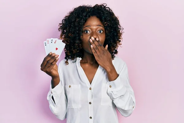 Young African American Woman Playing Poker Holding Cards Covering Mouth — Stockfoto