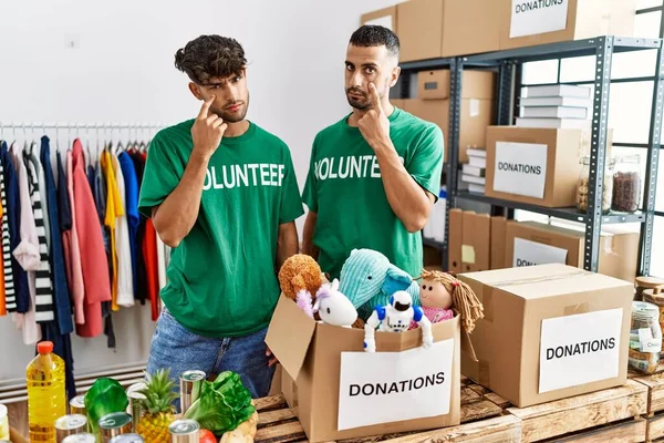 Joven Pareja Gay Vistiendo Camiseta Voluntaria Stand Donaciones Apuntando Ojo —  Fotos de Stock