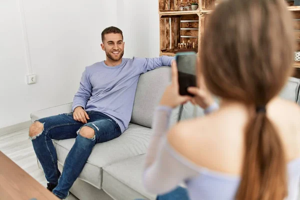 年轻女人在家里用智能手机给男朋友拍照 — 图库照片