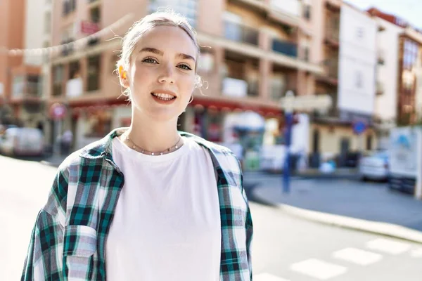 Modern beyaz saç stili ile genç ve güzel bir kadın dışarıda mutlu bir şekilde gülümsüyor.