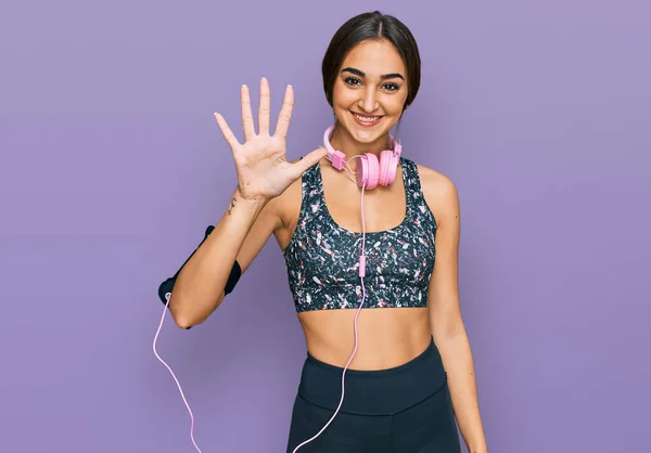 Beautiful Brunette Woman Wearing Gym Clothes Using Headphones Showing Pointing — 스톡 사진