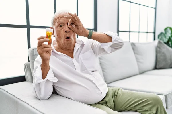 Uomo Anziano Che Tiene Pillole Facendo Gesto Scioccato Con Faccia — Foto Stock